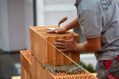 Maurer maurt wand aus rotem Porotonziegel